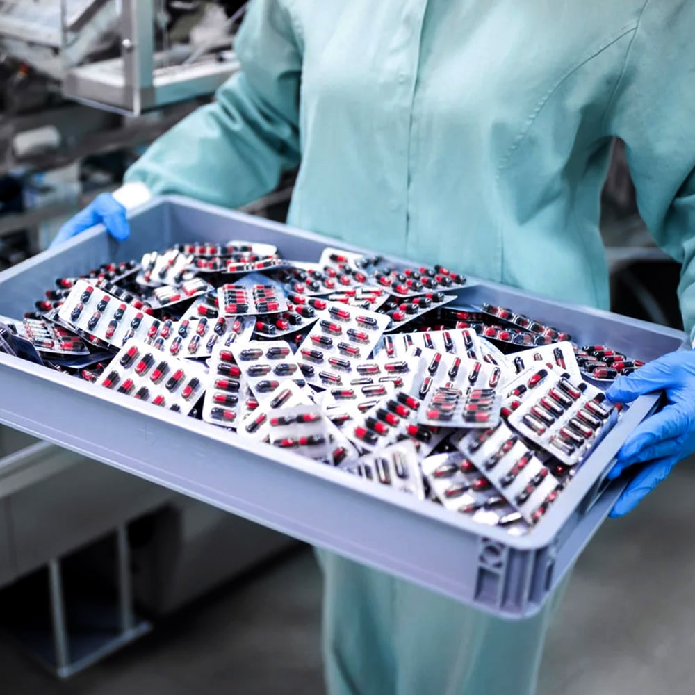 Worker holding tray with pills