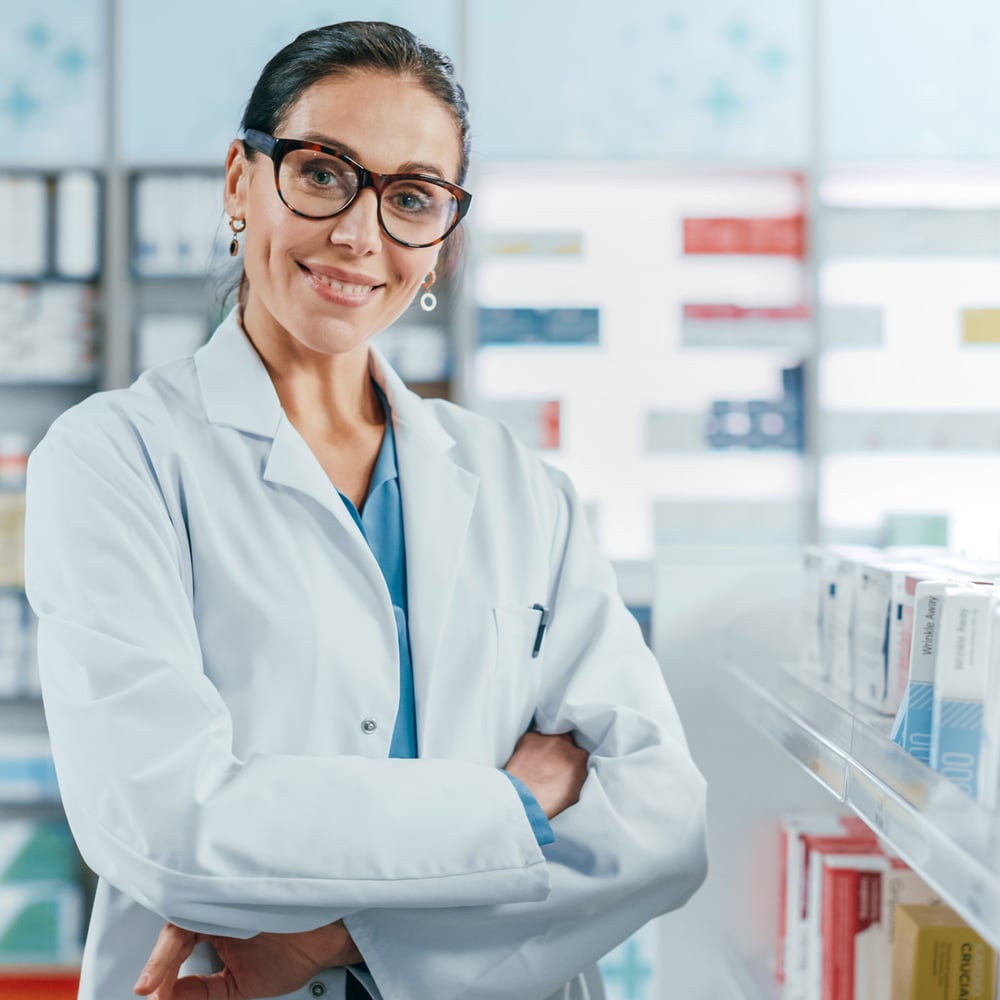 Pharmacist in front of pharmacy racks