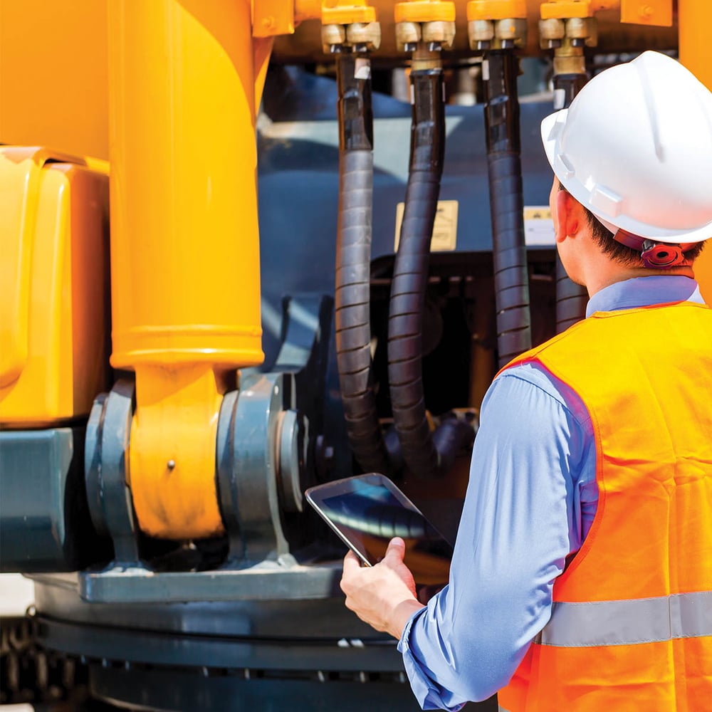 Engineer checking motor of heavy equipment
