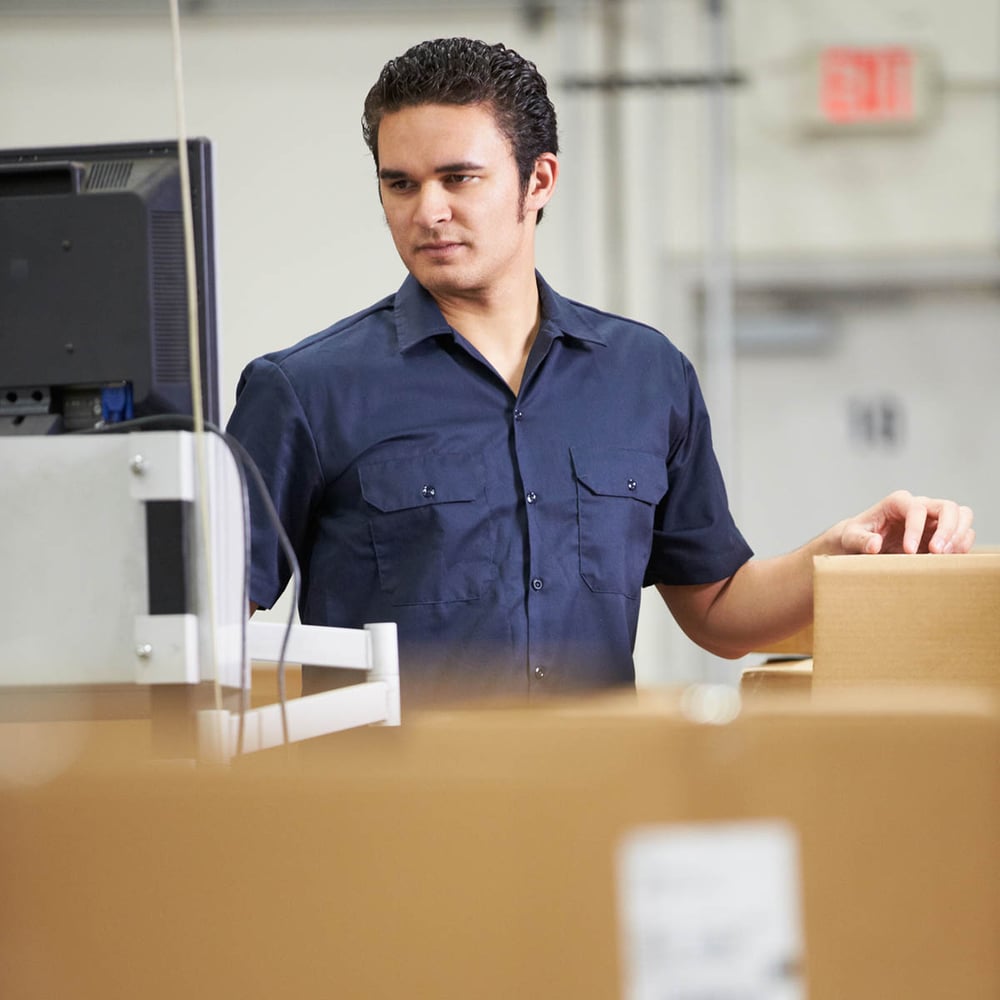 Warehouse Worker checking information on computer
