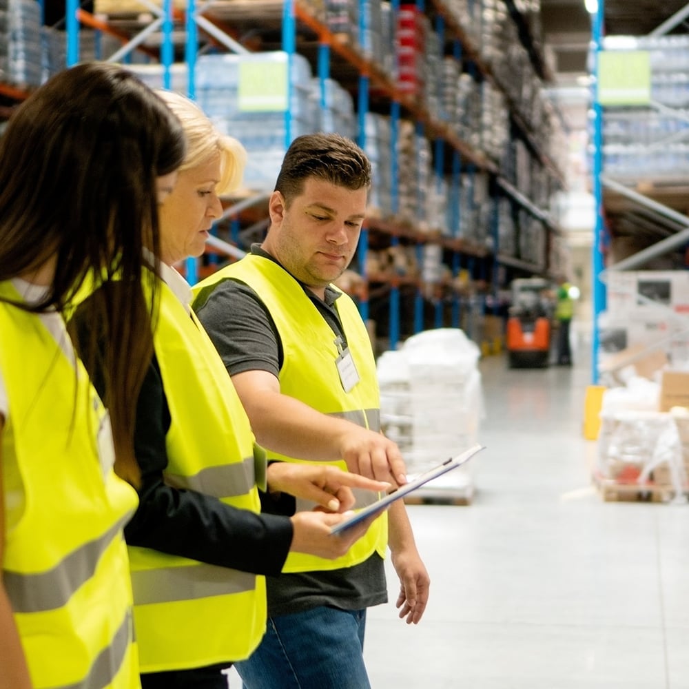 three warehouse experts looking at digital screen