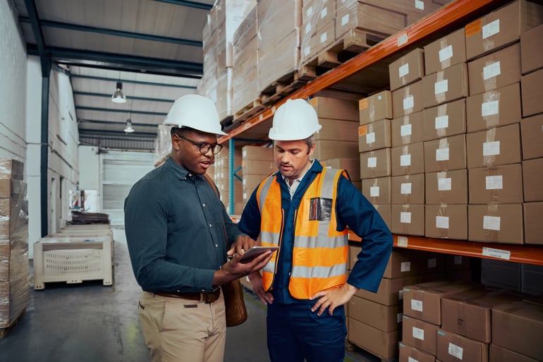 warehouse workers discussing AdobeStock_396781844